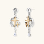 Two-tone star earrings with gold celestial motifs, silver chains, and clear crystal droplets on white background.