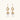 Gold sunburst charm earrings with baroque pearl drops on French hooks against cream background