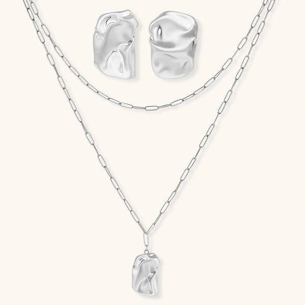 Modern textured hoop earrings and layered chain necklace with liquid metal pendant in silver and gold finishes.