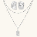 Modern textured hoop earrings and layered chain necklace with liquid metal pendant in silver and gold finishes.