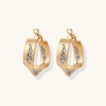 Sculptural wavy hoop earrings with crystal details and organic curved silhouette in gold and silver variants