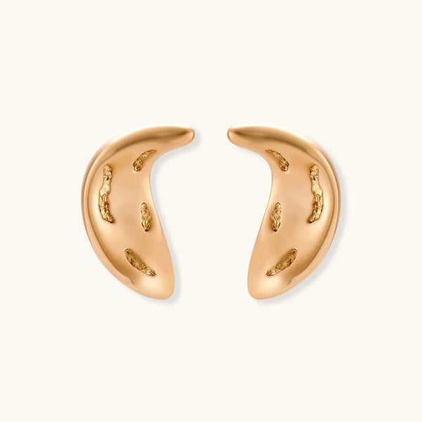 Pair of gold crescent moon-shaped stud earrings with textured surface details on cream background.