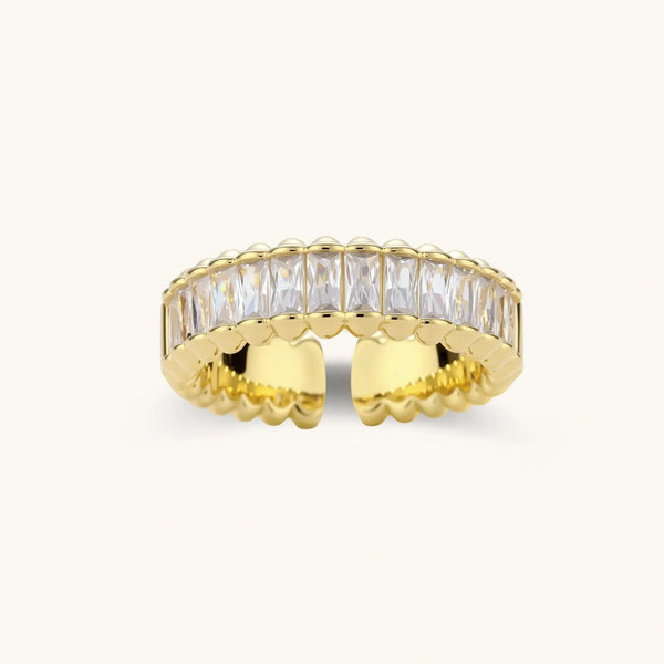 Adjustable gold-plated ring with rectangular cubic zirconia stones in eternity band style on neutral background.