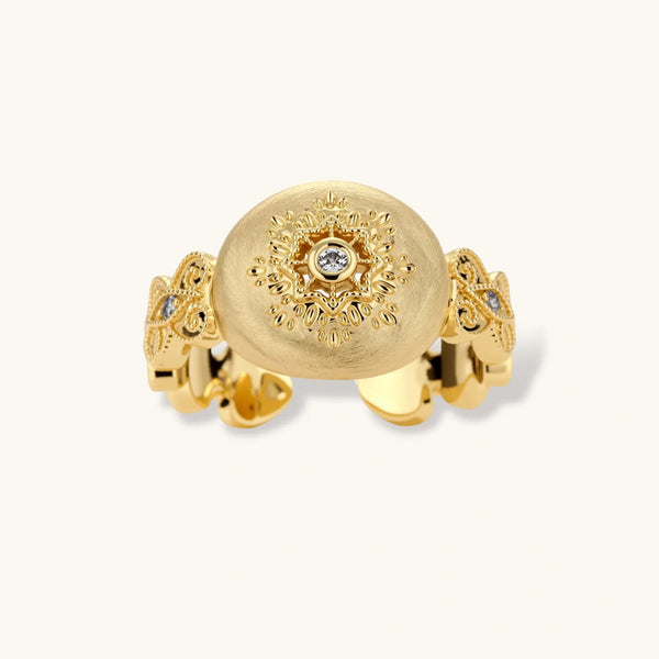 Ornate gold-plated ring with detailed engravings and central zirconia stone on adjustable band